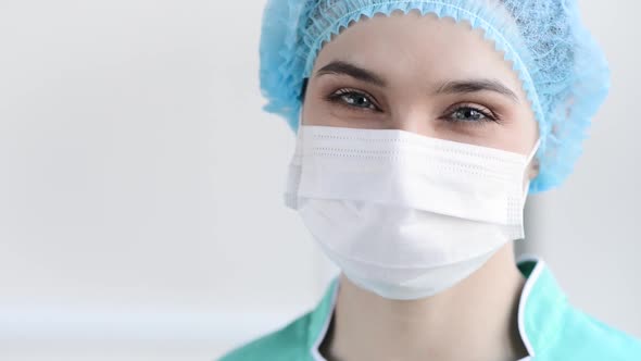 Medical nurse or scientist in surgical mask on blurred background in a hospital or lab