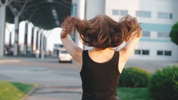 Beautiful Redhaired Woman with Long Hair on Street at Sunset