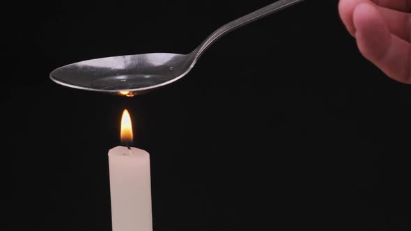 Cooking Drugs in a Spoon on a Candle Flame