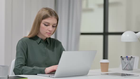 Young Woman Working on Laptop in Office