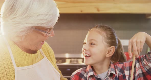 Little girl mixing the batter and happy grandmom guiding her 4K 4k