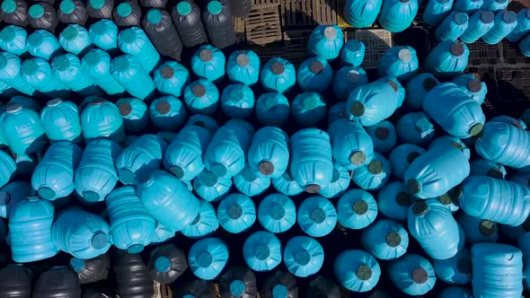 Aerial View of Blue and Black Plastics Barrels Tanks Open-air Warehouse