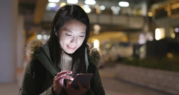 Woman using mobile phone at night