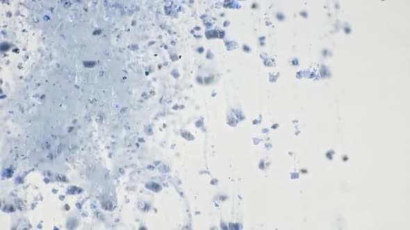 Macro Shot of Particles Made of Clay Powder Cosmetic Texture in Water Descend Up on White Background