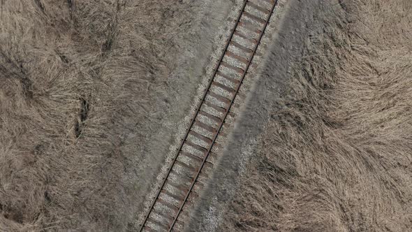 Rotating above the railroad track in the field 4K drone video