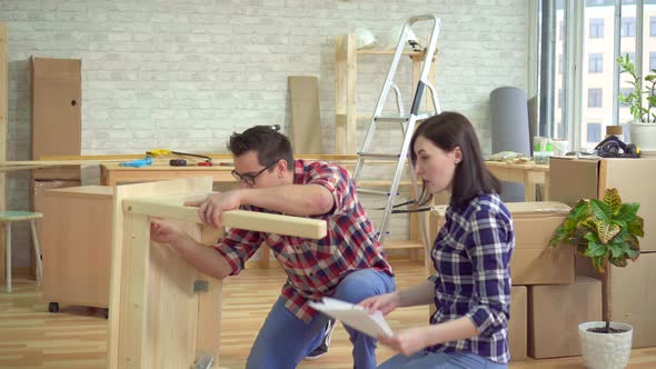 Young Married Couple Gathers a Bedside Table in a New Modern Apartment