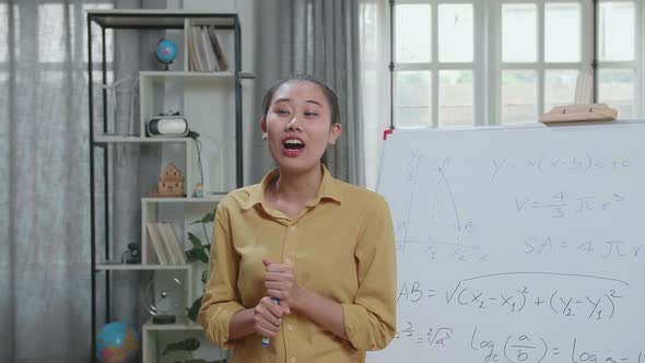 Asian Female Teacher With Marker Pen Teaching Math At Home