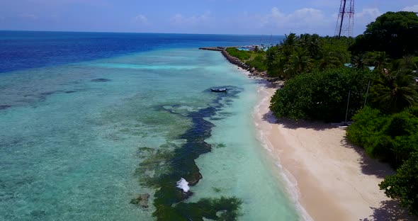 Wide overhead travel shot of a summer white paradise sand beach and blue sea background in 4K