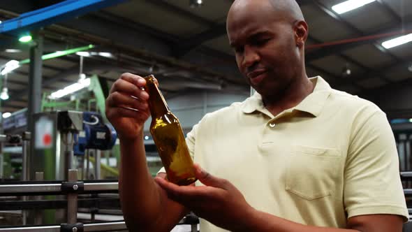 Smiling worker examining a bottle