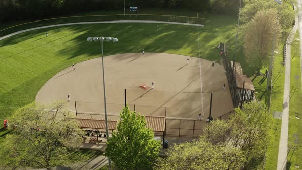 Aerial Drone Shot of Kids Play Baseball Field at Park on Sunny Day