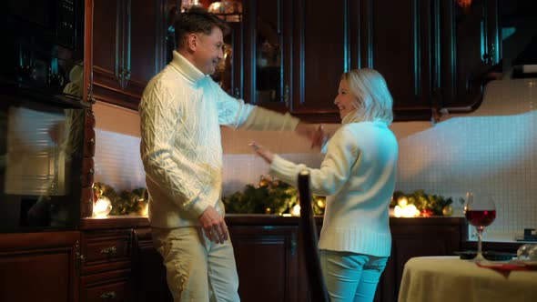 Joyful Dance of Cheerful Adult Couple in Kitchen at Home Indoors