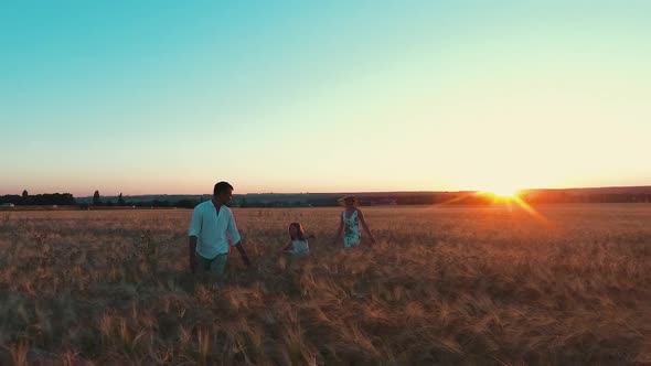 Family Walking at Sunset in Wheat Field