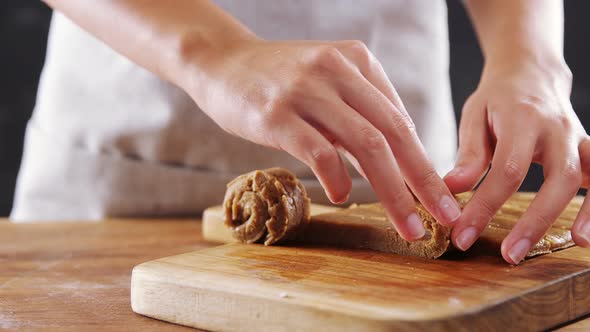 Woman rolling dough on chopping board