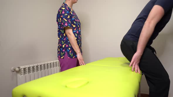 patient lies on stretcher following the instructions given by his physiotherapist