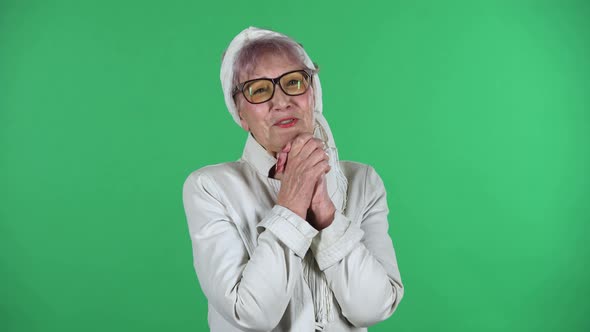 Portrait of Old Stylish Woman Is Looking with Tenderness with Folded Arms in Front of Her Isolated