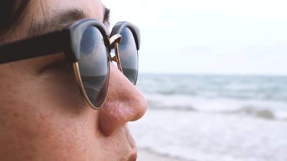 Young Man Looking at the Beach As It is Reflected in Man's Sunglasses  Summer Vacation Concept