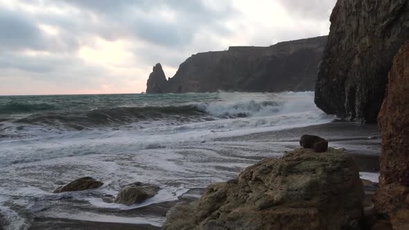 A Red Burning Sunset Over the Sea with Rocky Volcanic Basalt Cliff