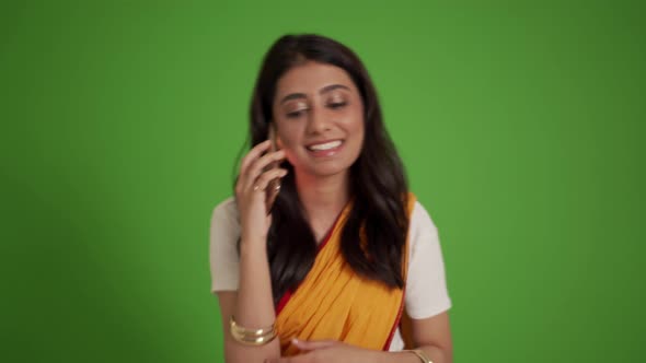 Smiling traditional Indian woman talking by phone