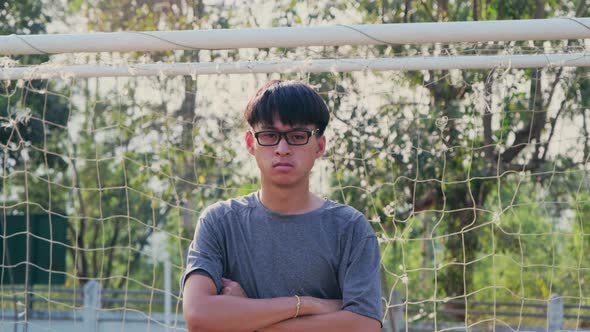 Portrait of a confident young man wearing glasses and wearing a casual gray t-shirt crossed arms.