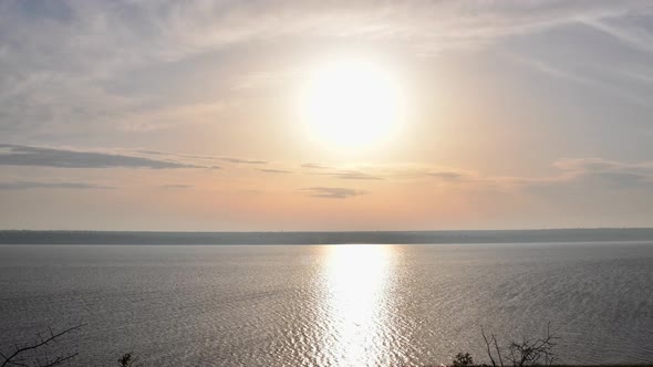 Time Lapse Sun Goes Down at Lake Shore with Reflection in Rippled Water Surface