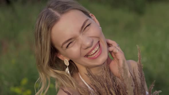 Young Woman Looking at Camera and Smiling. Happy Woman Enjoying Nature