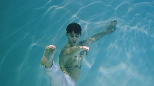 Underwater Shot of Man with a Halfnaked Torso Gracefully Dancing Modern Ballet Choreography