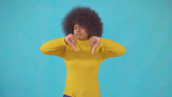 African Woman with an Afro Hairstyle in a Yellow Jacket with the Denial Showing Thumbs Down