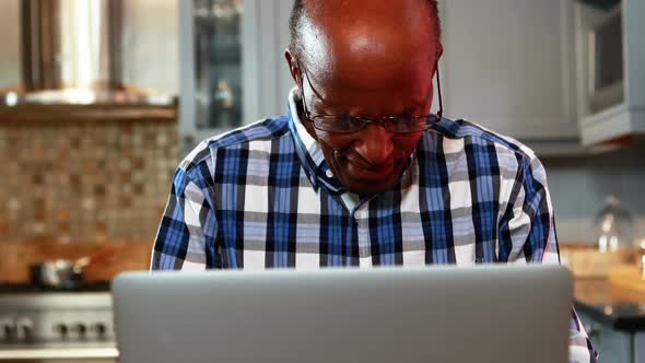 Stressed senior man using laptop