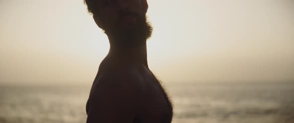 Man stretching his neck in front of the sea