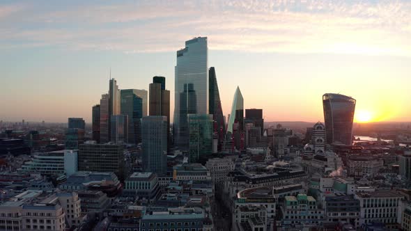 Circling aerial drone shot of Central London skyscraper buildings at sunrise close up