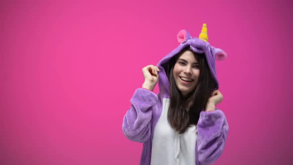 Smiling Woman Having Fun and Dancing in Funny Unicorn Pajamas, Carnival Party