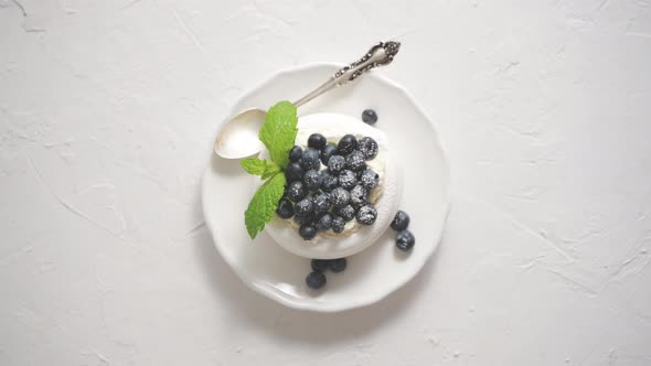 Delicious Mini Pavlova Meringue Nest with Blueberry and Mint Leaves