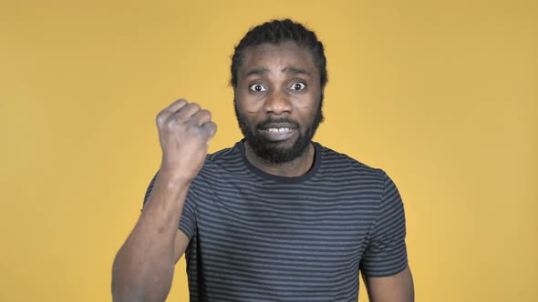 Fighting Angry Casual African Man Isolated on Yellow Background