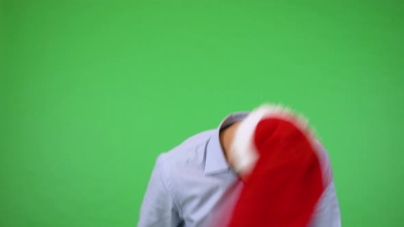 A Young Handsome Man Spins His Christmas Hat, Then Grins at the Camera - Green Screen Studio