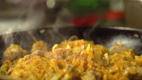 Frying pan with meat and vegetables close-up.