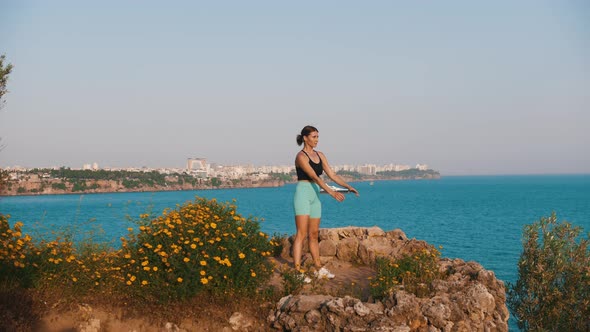 Sportive Woman Working Out on the Hill By the Sea  Squatting on the Spot