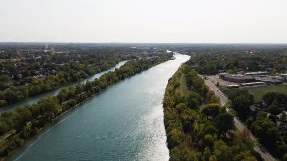 Wide river with narrow canal on the side. Aerial view of Welland canal in Canada with downtown in th