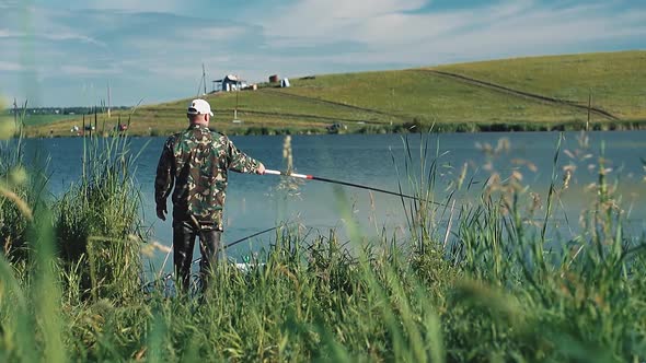 Fisherman in Camouflage Clothes Catches