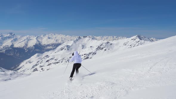 Skier Skiing Down Snowy Piste In Mountain Slope In Winter On Skis