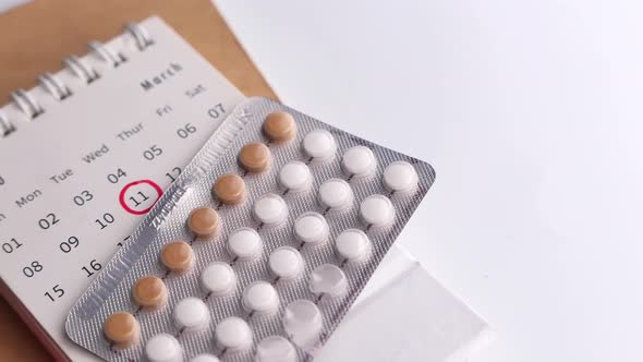 Birth Control Pills , Calendar and Notepad on Table 