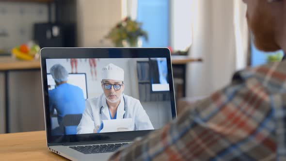 Young Male Patient Having Video Consultation with Doctor on Laptop