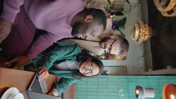 Multicultural Business Team Working on Laptop in Cafe