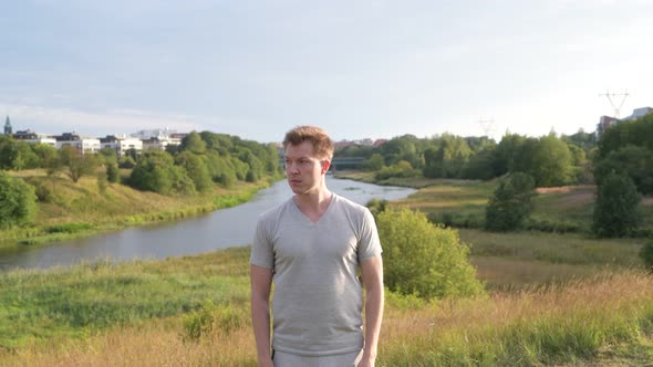 Young Happy Handsome Man Looking Around Against Beautiful Relaxing View of Nature