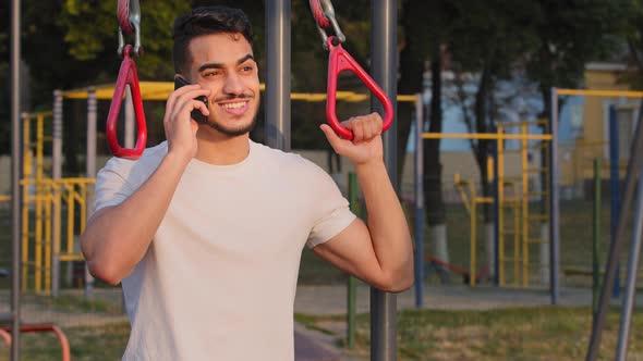 Indian Guy in Sportswear Talking on Phone Sportsman Call Talks on Cellphone During Workout