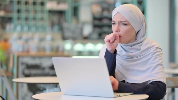 Sick Young Arab Woman with Laptop Coughing