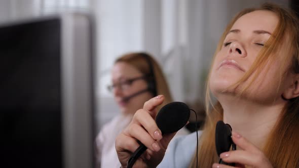 A Tired Woman Takes Off Her Headphones After a Hard Day's Work in a Call Center