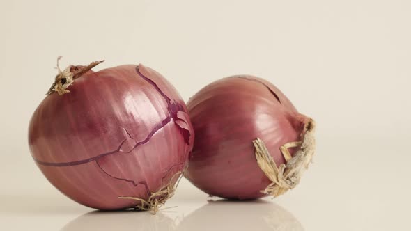 Tilting over onion with red skin and white flesh 4K 2160p 30fps UltraHD footage - Close-up of Allium