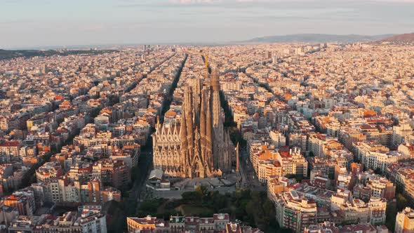 Rising pan down drone shot of La Sagrada Familia Basilica Barcelona at sunrise