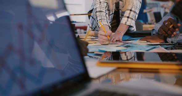 Close-up View of Multiethnic Team Working Together Behind Office Table, Woman Speaking Is Seen in