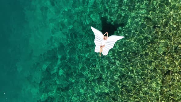 The girl is swimming in the sea. View from the air. Vacation and relaxation. Blue sea and coastline.